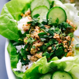 Wrapped chicken larb with fresh vegetables and herbs.