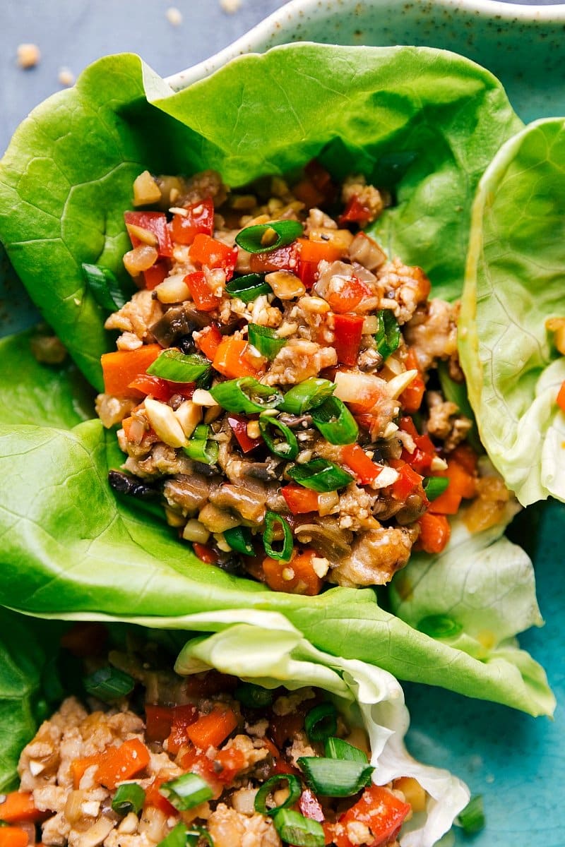 Chicken lettuce wraps garnished with herbs and vegetables.