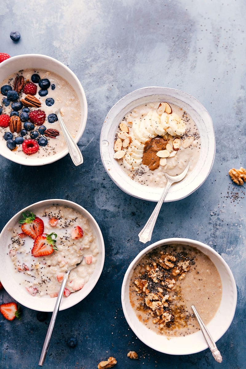 Four bowls of oatmeal, all with different toppings.