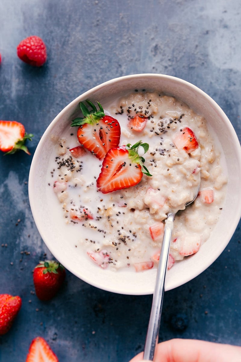 Bowl of creamy strawberries and cream oatmeal, garnished with fresh sliced strawberries.