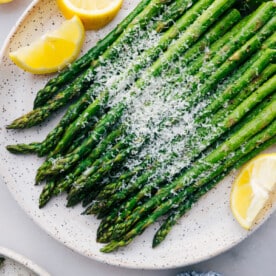 Easy roasted asparagus with fresh parmesan cheese and lemon slices.