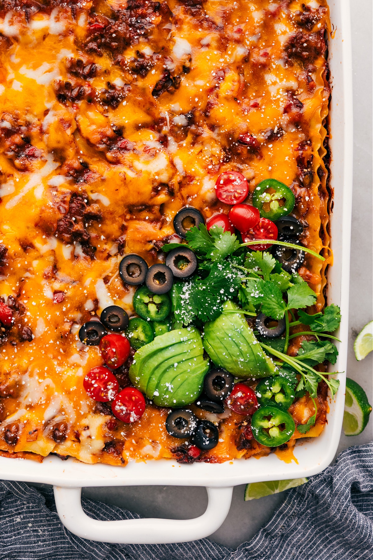 The taco lasagna recipe ready to be served with toppings on top.