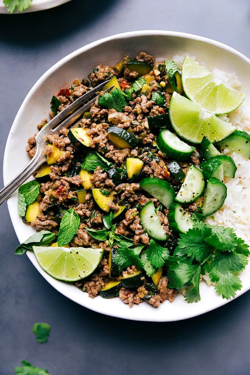 Photo of Beef Larb, rice and garnishes of lime and cilantro.