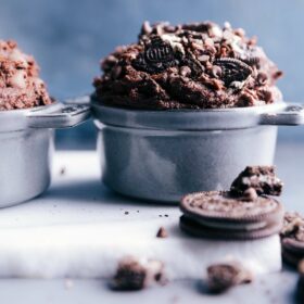 Edible brownie batter in a bowl, enhanced with chunks of oreos and chocolate chips.