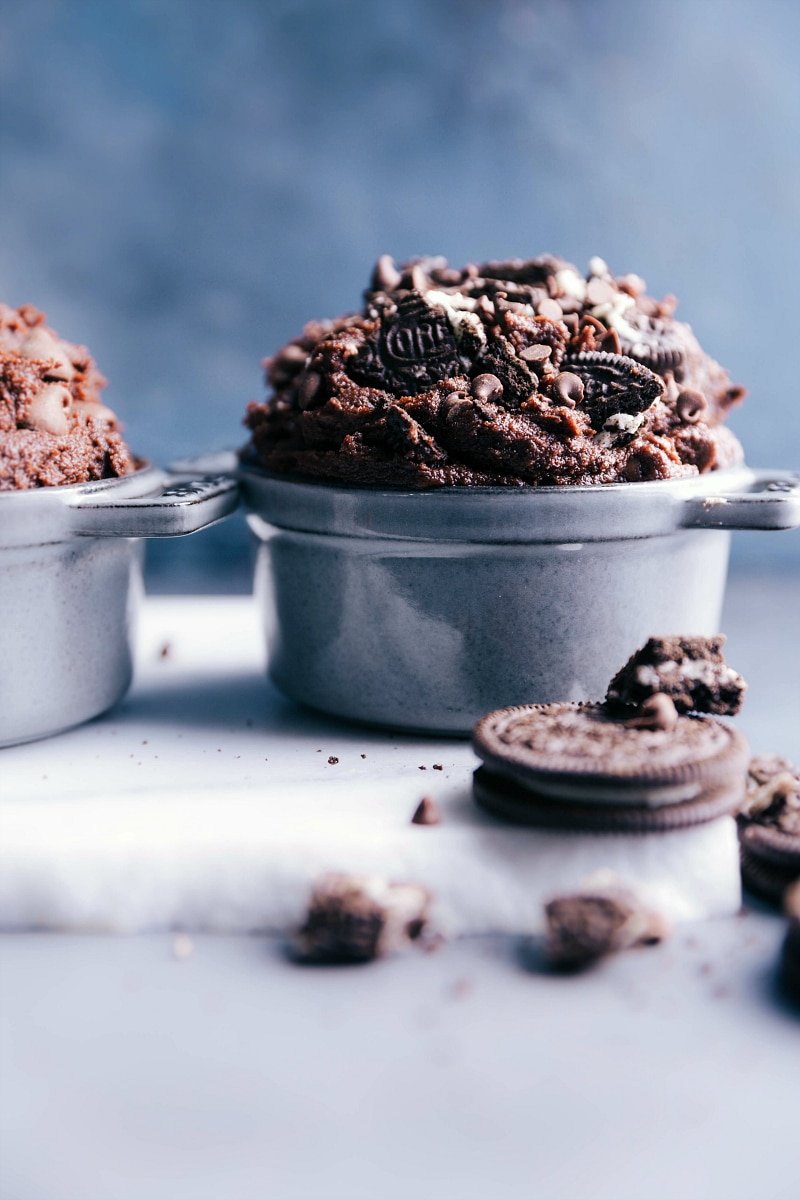 Edible brownie batter in a bowl, enhanced with chunks of oreos and chocolate chips.