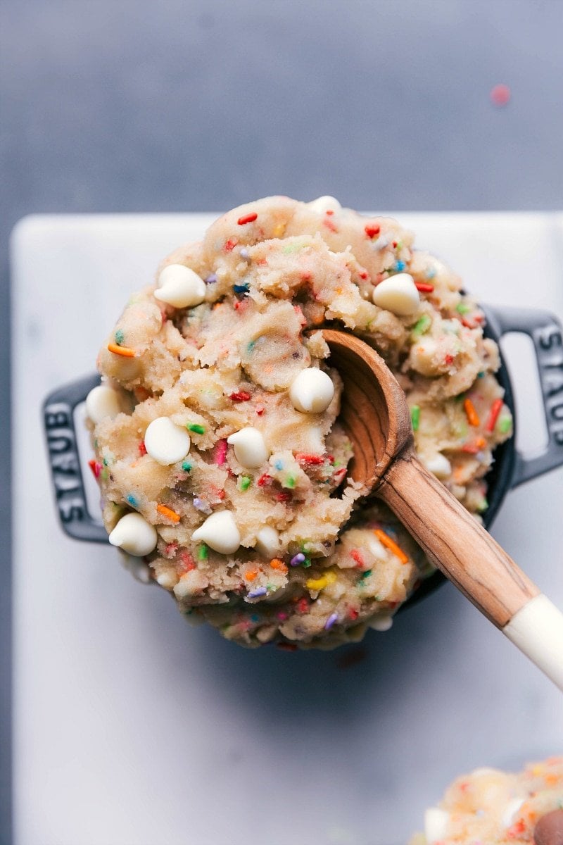 Scrumptious edible cake batter in a bowl, complete with a spoon, ready for indulgence.