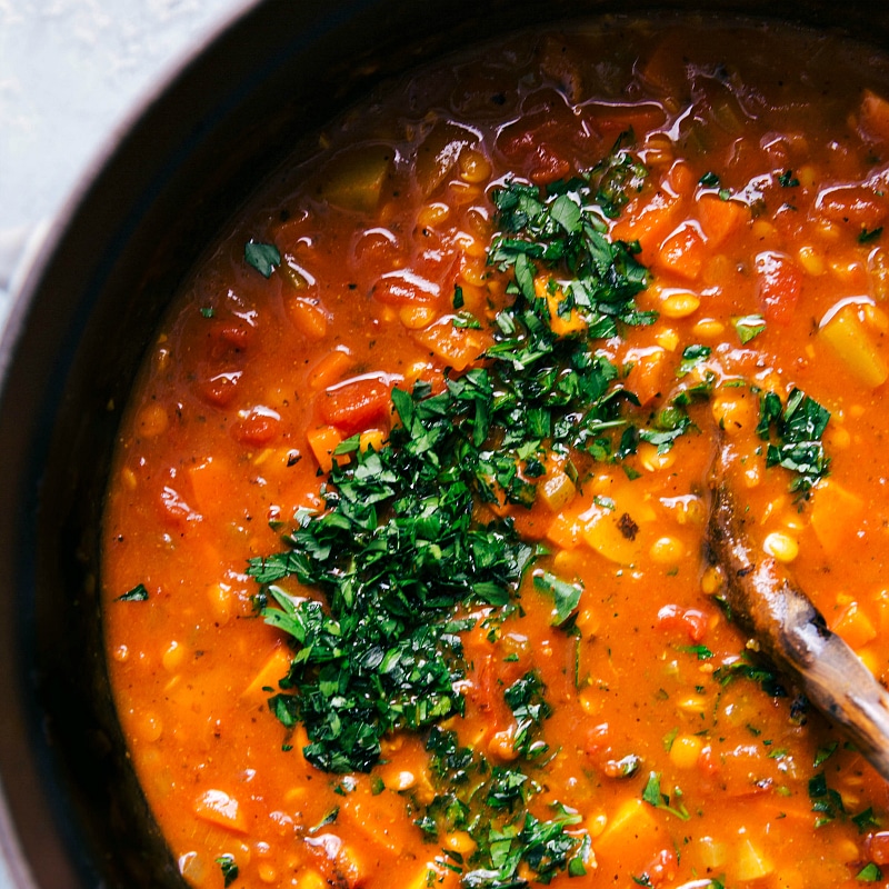 Overhead image of Lentil Soup with fresh chopped parsley on top, about to be stirred in.