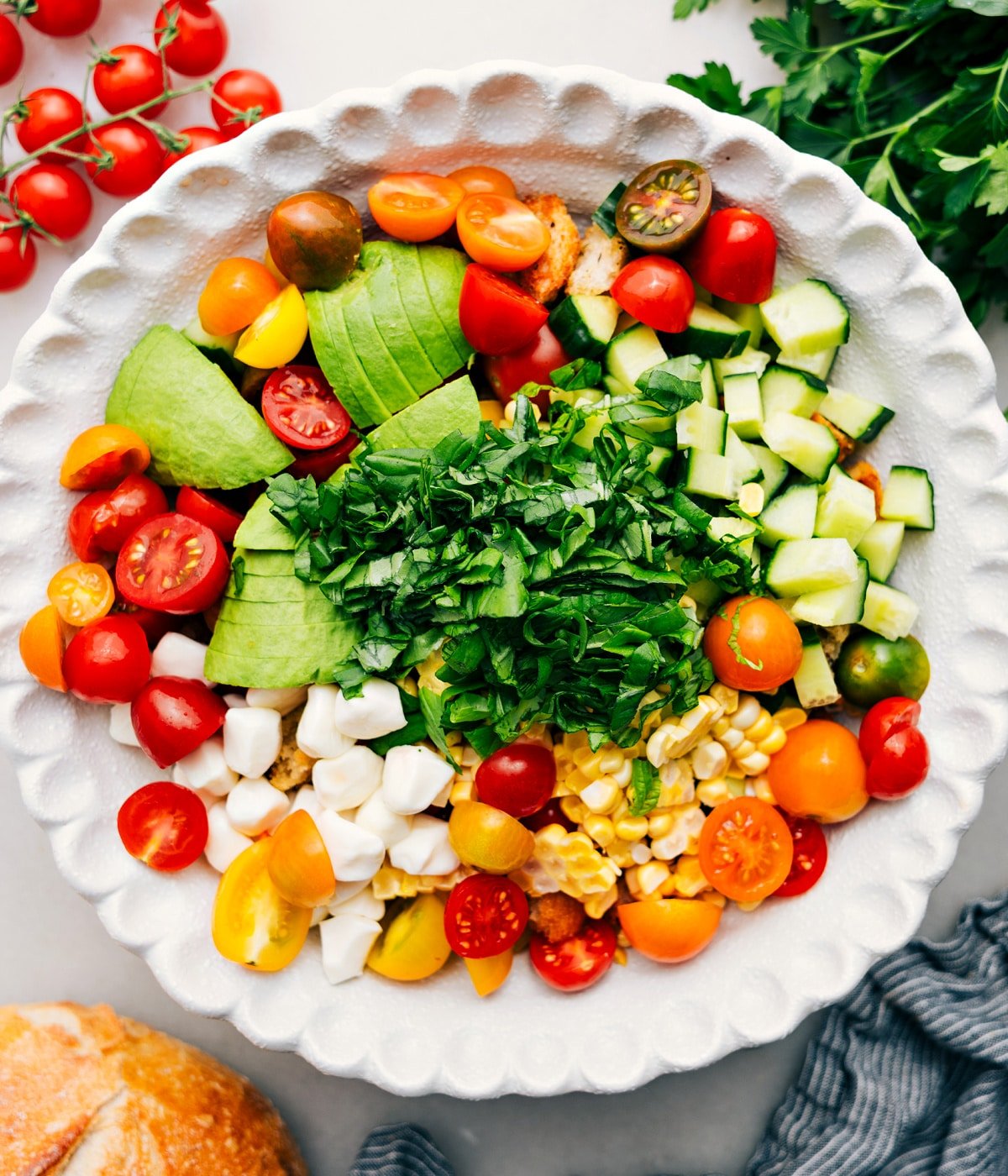 Add all the fresh components for the panzanella to a bowl, ready to be tossed with the bread and dressing.