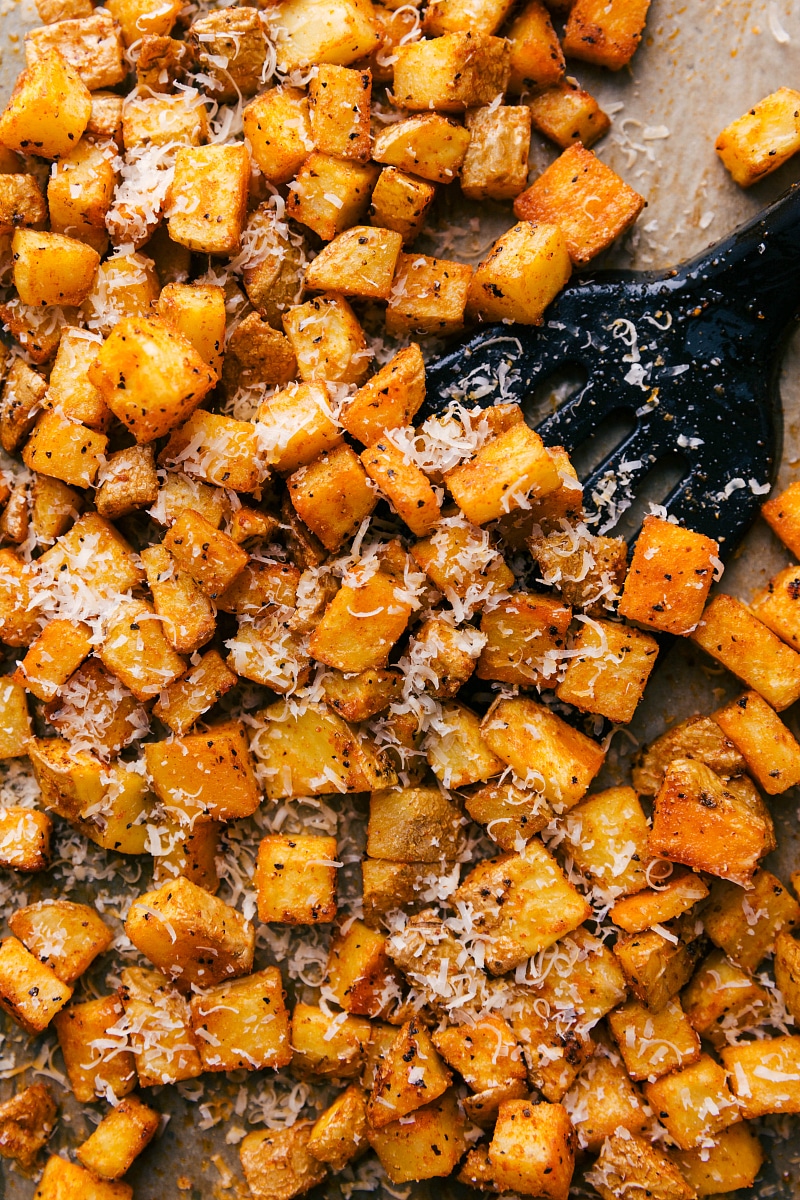 Overhead image of Roasted Potatoes being scooped up with a spatula.