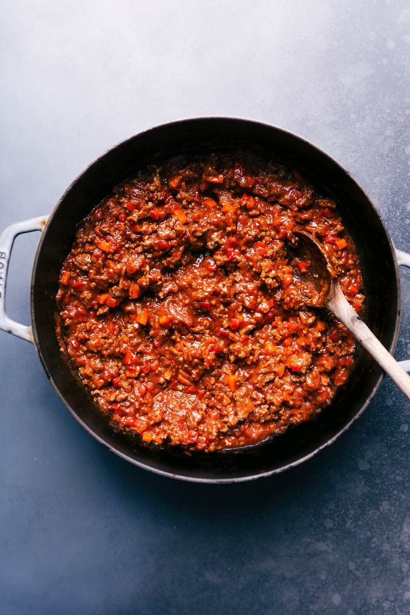 Overhead image of the Sloppy Joes mixture in a skillet, with a spoon in it.