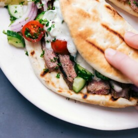 Steak gyros fully stuffed with succulent meat, fresh vegetables, and a delicious sauce, ready to be eaten.