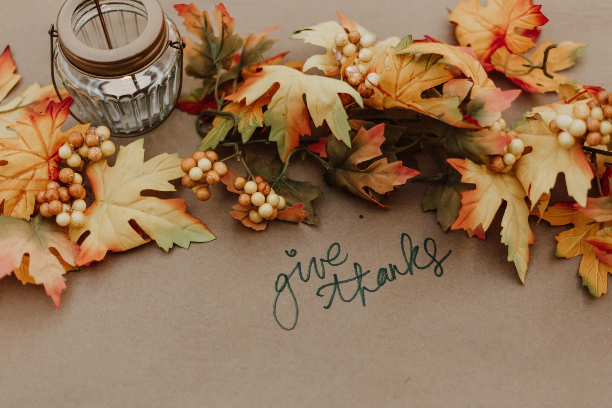 A collection of fall foliage with the message saying "give thanks."