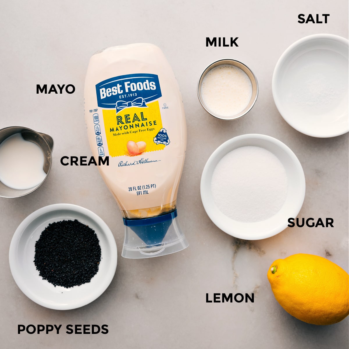 The dressing ingredients for this blackberry salad are prepped for easy assembly, including mayo, cream, sugar, lemon, milk, salt, and poppyseeds.