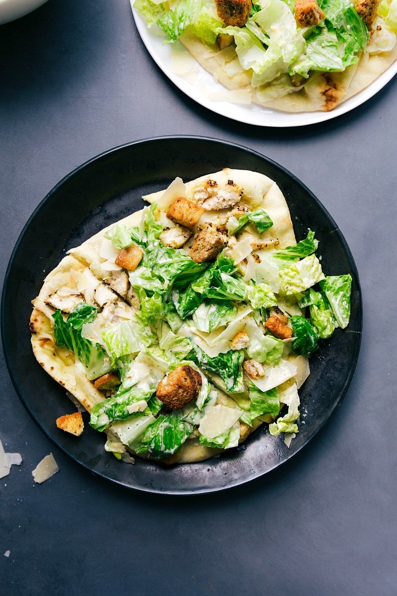 Overhead image of Caesar Salad Pizza cut up and ready to be eaten.