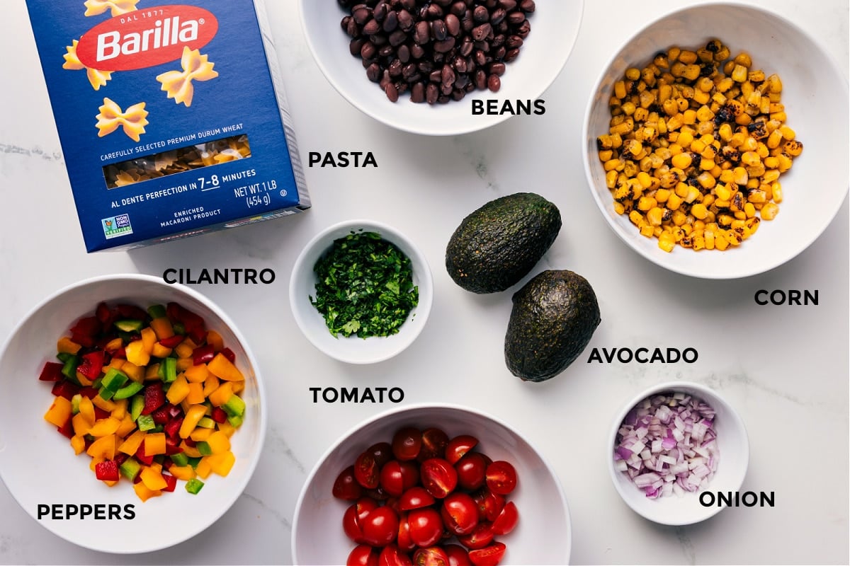 All the ingredients prepped for easy assembly—beans, pasta, corn, avocado, onion, tomato, cilantro, and peppers.
