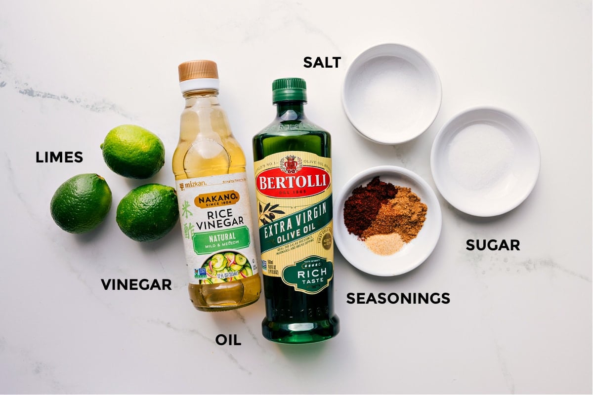 The dressing ingredients prepped for Mexican Pasta Salad—limes, rice vinegar, olive oil, seasonings, sugar, and salt.