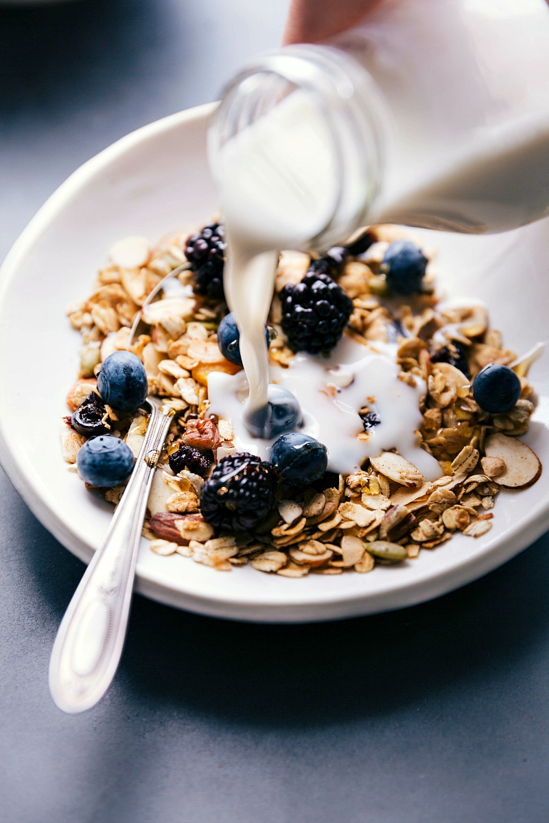 Milk being poured over freshly prepared breakfast, completing the wholesome breakfast dish.