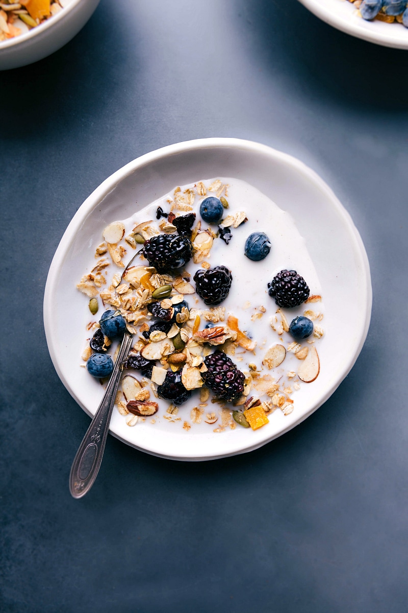 Homemade muesli cereal in a bowl with milk and berries, ready for a healthy and delicious breakfast.