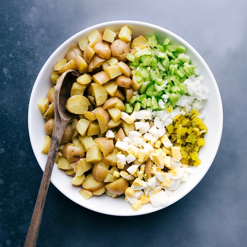 Overhead view of the ingredients: cooked and chopped Yukon gold potatoes, diced celery, onion, hard-boiled eggs and pickles.