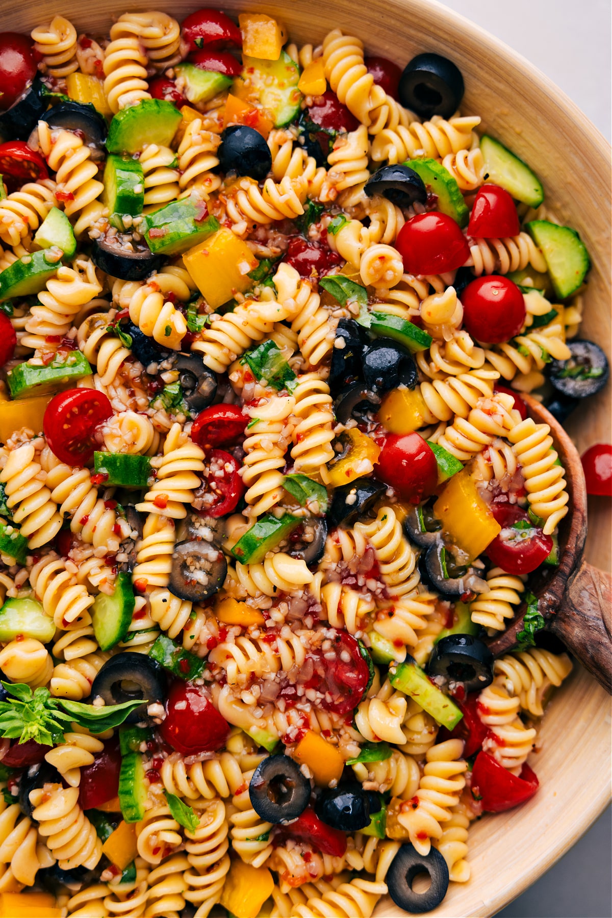 A bowl of Pasta Salad with a spoon in it.