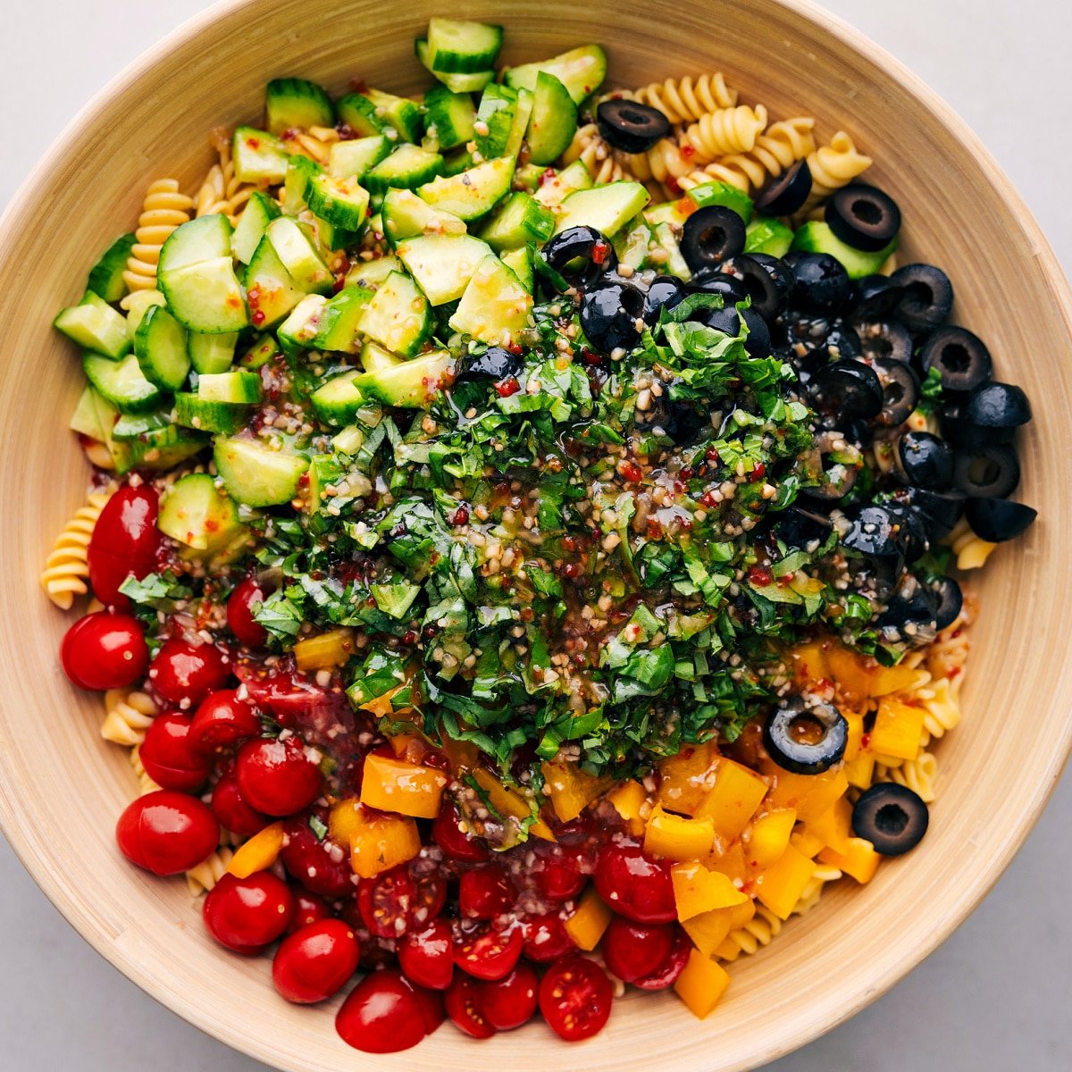 The dressing being added to the ingredients in a bowl.