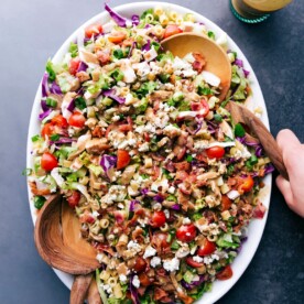 A vibrant bowl of Portillo's Chopped Salad with two serving spoons.