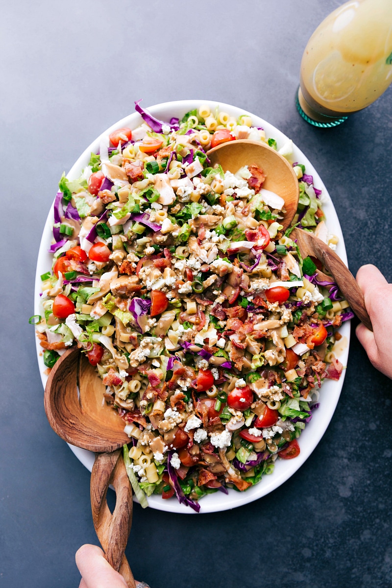 A vibrant bowl of Portillo's Chopped Salad with two serving spoons.