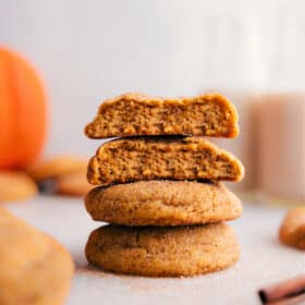 Stack of pumpkin snickerdoodles with one cookie split open, revealing the soft, moist center.