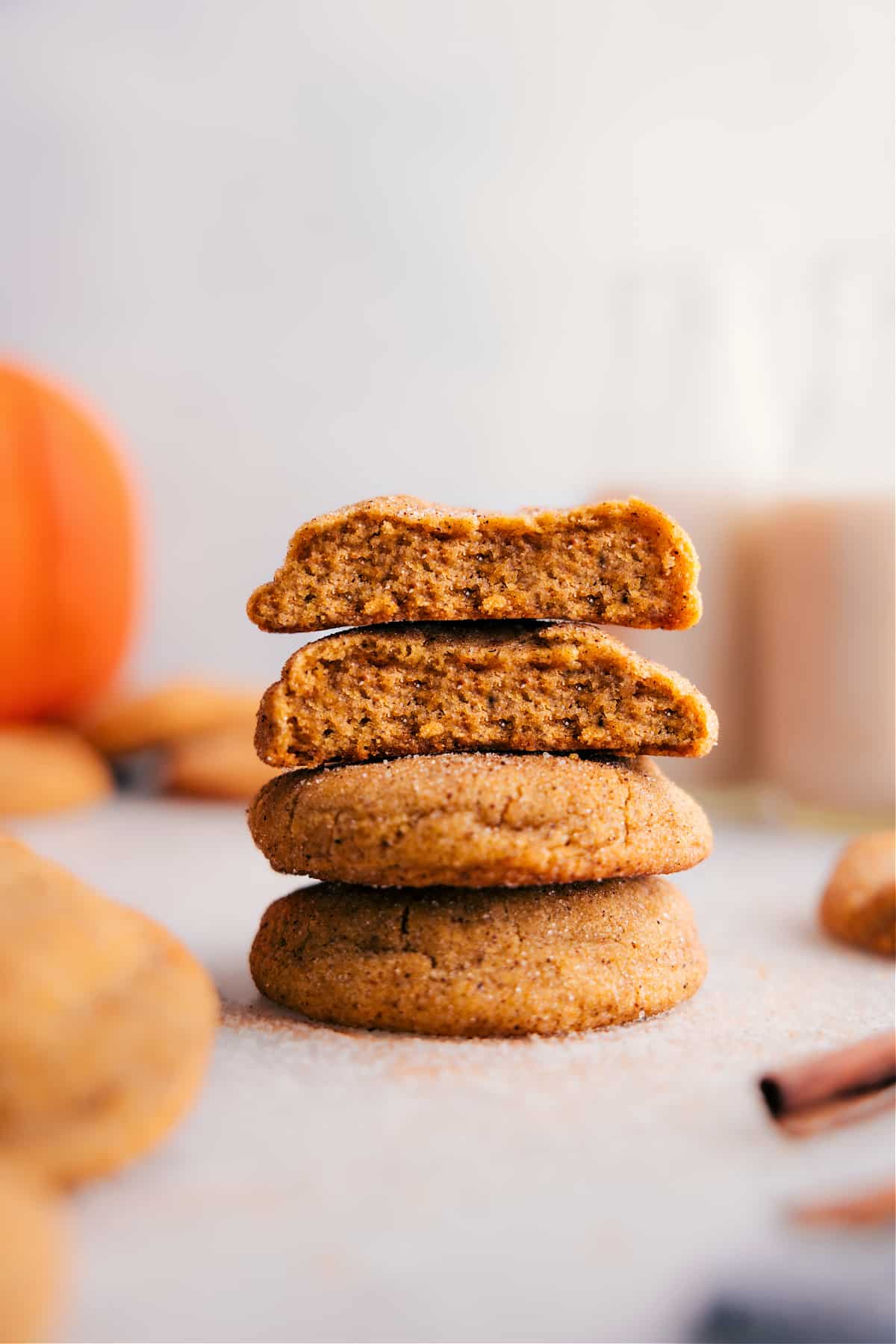 Stack of pumpkin snickerdoodles with one cookie split open, revealing the soft, moist center.