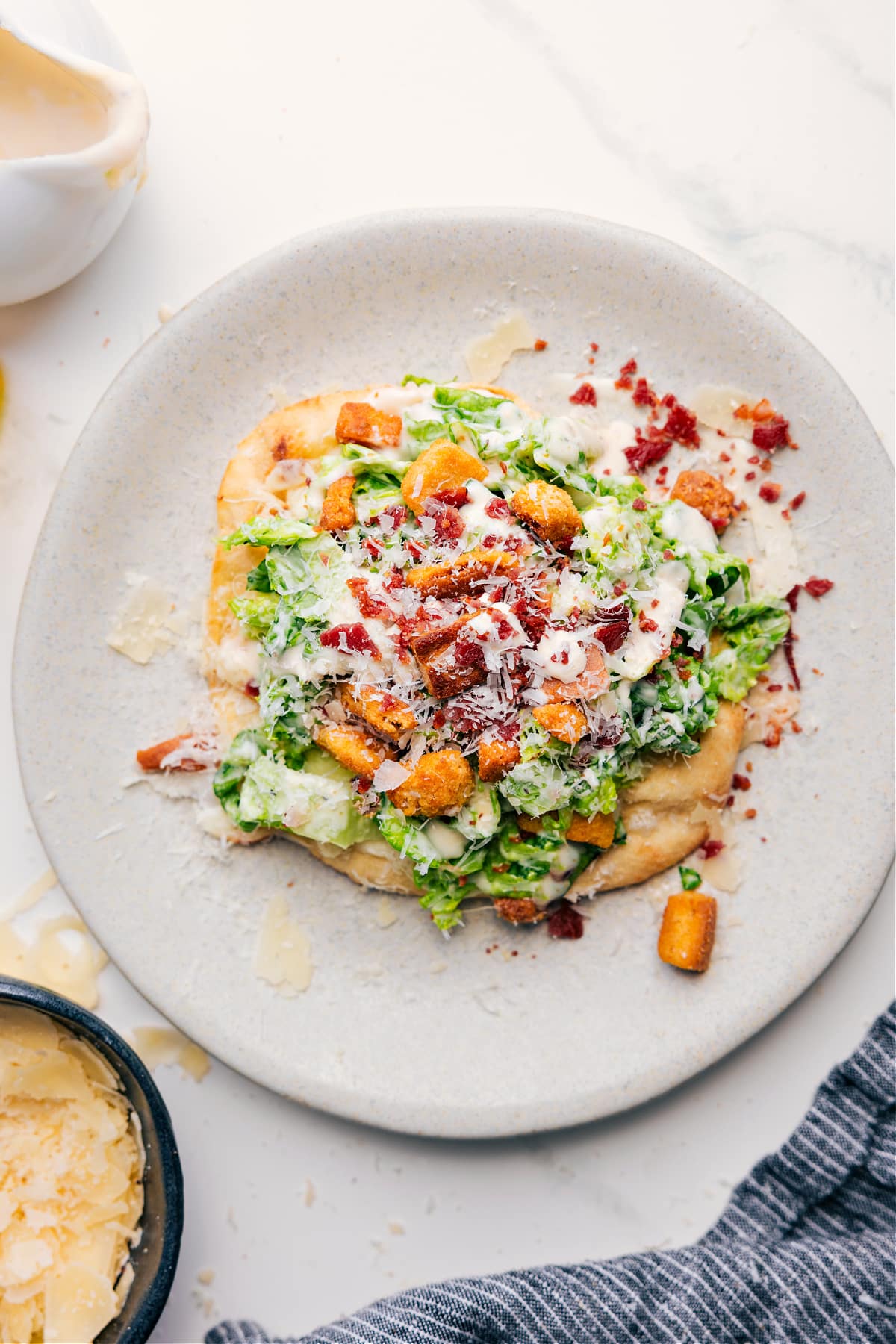 Caesar Salad Pizza on a plate ready to be enjoyed.