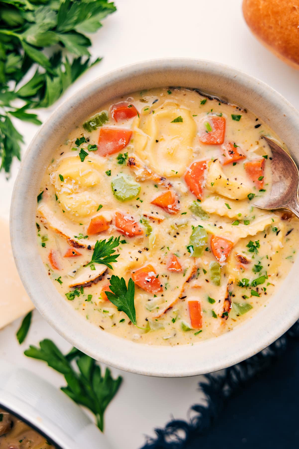 Creamy Chicken Tortellini Soup in a bowl topped with fresh parsley.