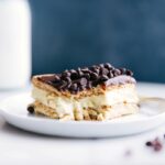 A delicious slice of eclair cake with a bite taken out, revealing its creamy center.