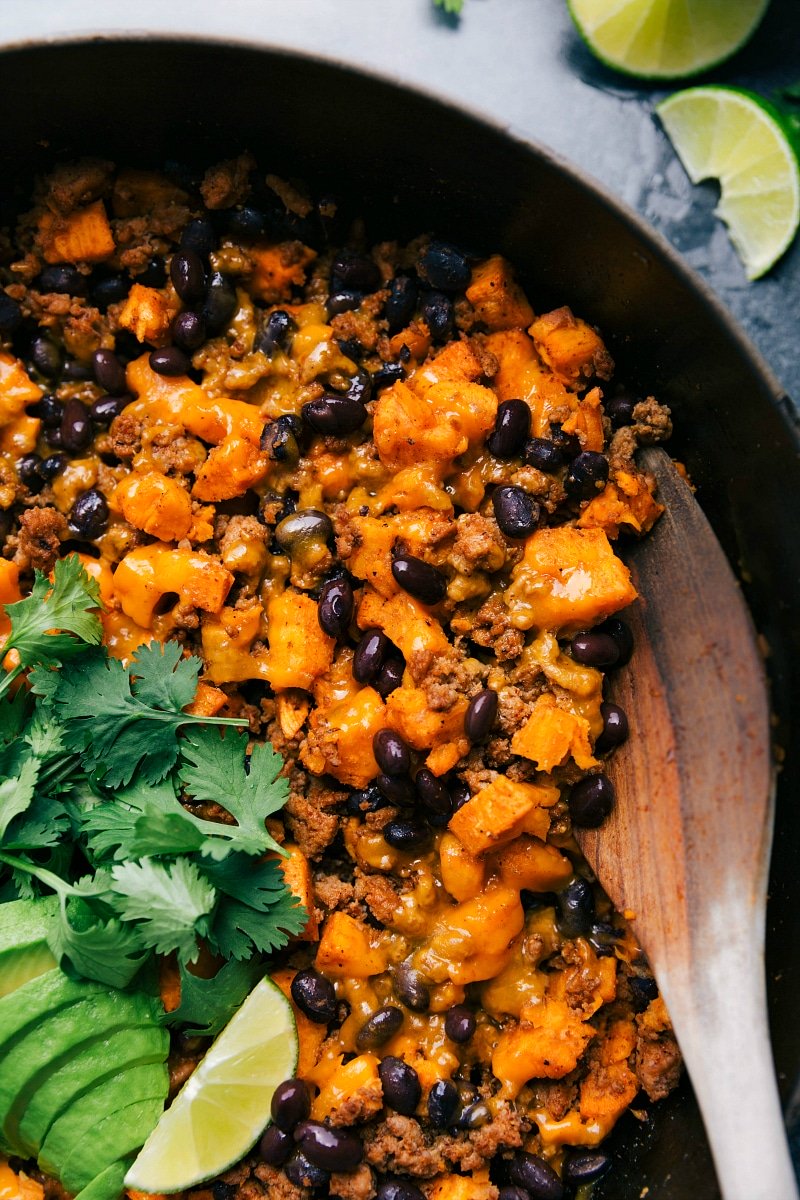 Image of Ground Turkey Sweet Potato Skillet garnished with avocado, cilantro, and lime.