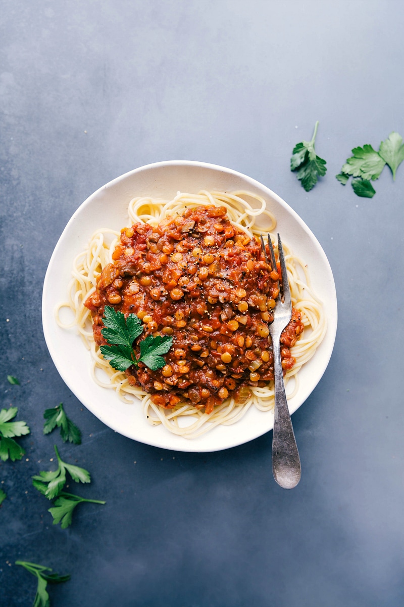 Overhead view of spaghetti topped with Lentil Bolognese sauce.