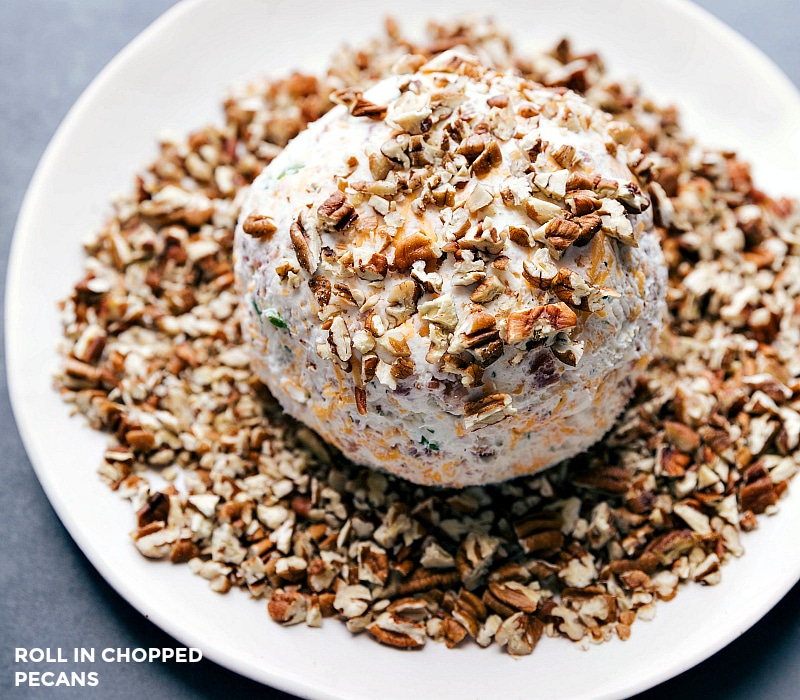 Image of the Cheese Ball recipe being rolled in the chopped pecans.