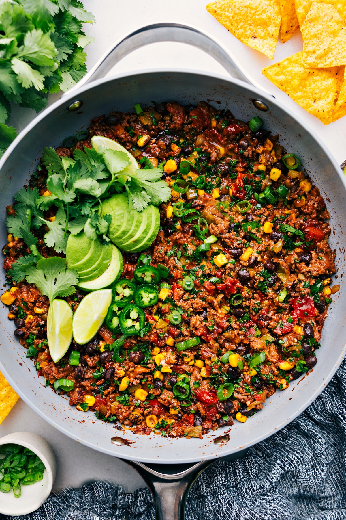 The Best Taco Skillet Recipe Taco Skillet in the pot, topped with avocado, cilantro, lime, and jalapeño, ready to enjoy.