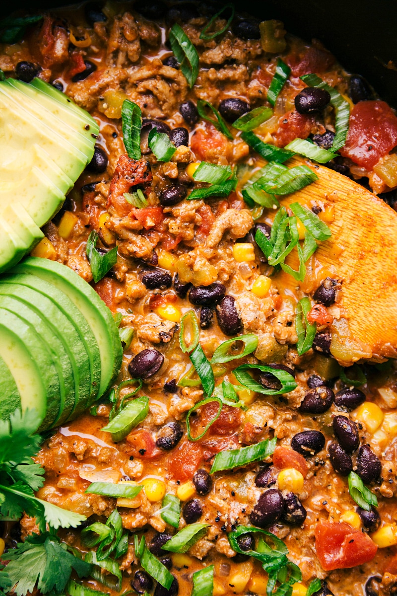 Close-up view of the finished Turkey Taco Skillet, with sliced avocado, cilantro and green onions for garnish.