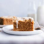 A slice of apple coffee cake on a plate, topped with delicious frosting.