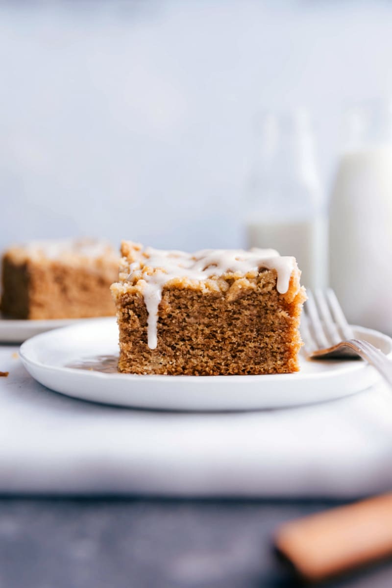 A slice of apple coffee cake on a plate, topped with delicious frosting.