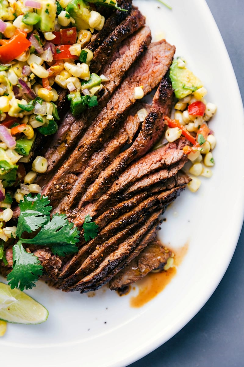 Up-close overhead image of sliced Flank Steak with Corn Salsa about to be eaten.