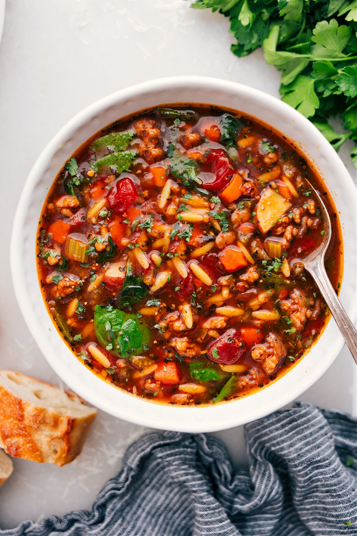 The Best Italian Sausage Orzo Soup Recipe Italian Sausage Orzo Soup in a bowl with a spoon, ready for you to dig in.