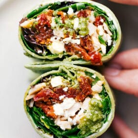 Delicious mediterranean wrap cut in half, revealing the beautifully layered contents.