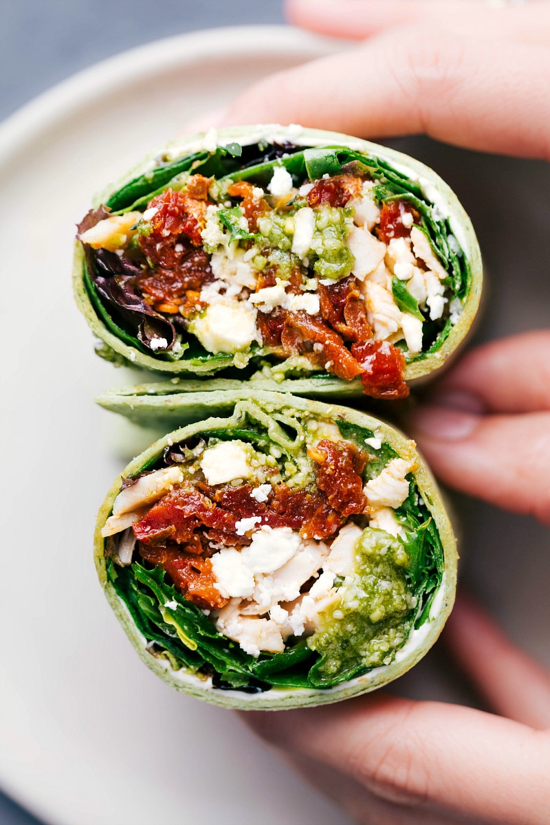 Delicious mediterranean wrap cut in half, revealing the beautifully layered contents.