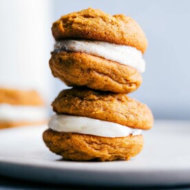 Two pumpkin whoopie cookies stacked on top of each other with a delectable filling.