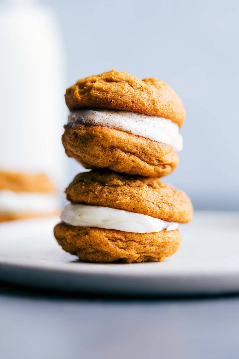 Two pumpkin whoopie cookies stacked on top of each other with a delectable filling.