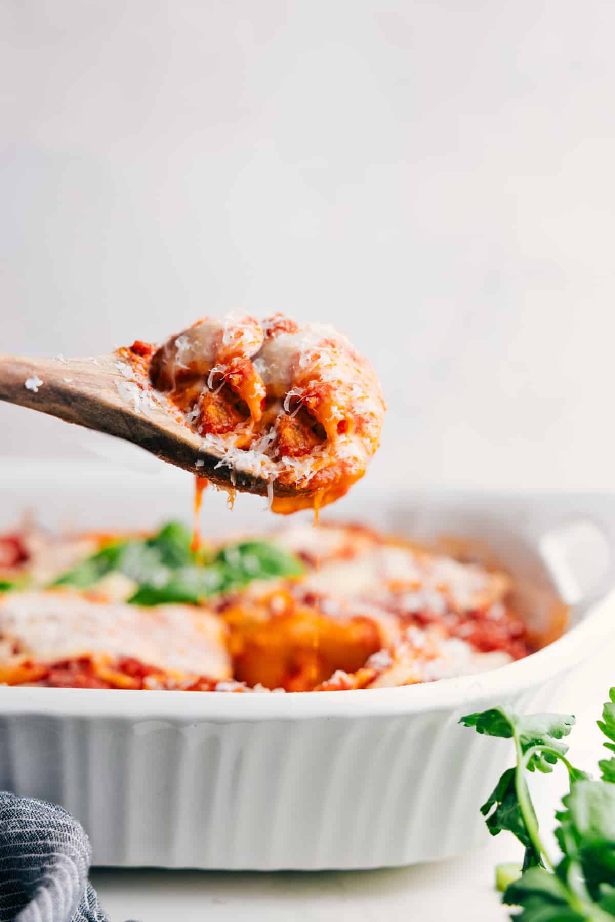 Serving Hearty Stuffed Shells with Italian Sausage A big scoop of this cheesy dish being lifted from the pan and ready to serve.