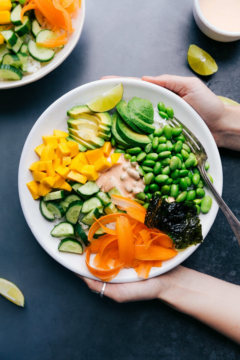 Vegetarian sushi bowl with all the ingredients arranged together and the sauce in the middle.