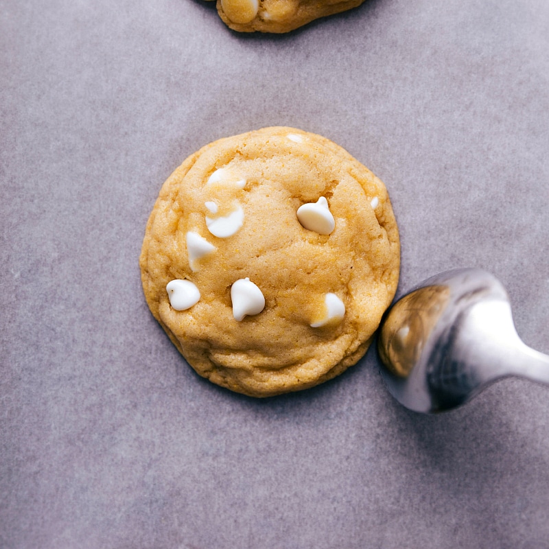 A freshly baked cornmeal cookie, rounded by using the back of a spoon while still warm, ready to be enjoyed as a delicious treat.