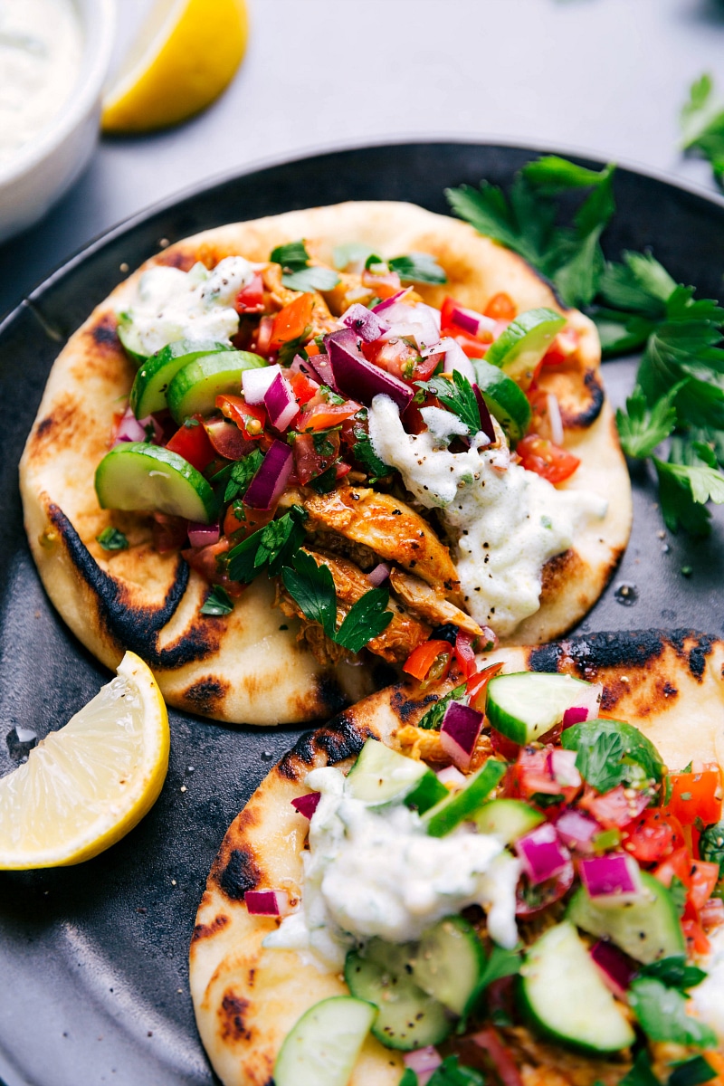 Chicken Shawarma Wraps - Flavorful Delights Two finished chicken shawarma wraps topped with delicious vegetables and sauce.