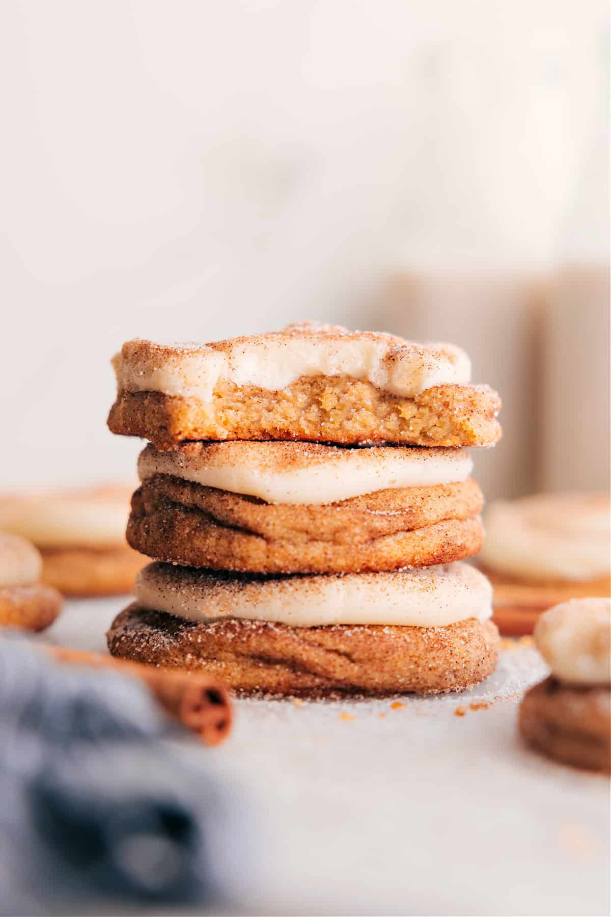 Cinnamon Roll Cookies Recipe Stacked Cinnamon Roll Cookies on a plate, topped with cream cheese frosting.
